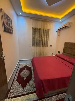 a bedroom with a bed with a red blanket at appartement Jalal in Marrakech