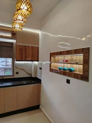 a kitchen with wooden cabinets and a chandelier at appartement Jalal in Marrakech