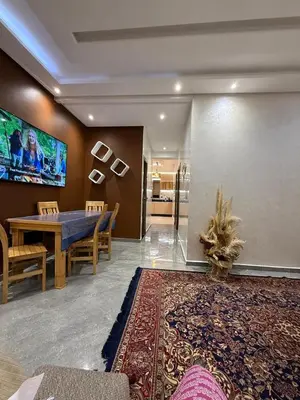 a dining room with a table and a tv at appartement Jalal in Marrakech