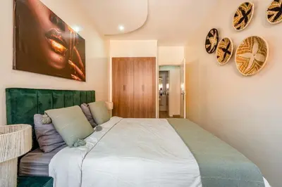 a bedroom with a large bed with a green headboard at Luxury 2BR Apt in Gueliz, Pools, Parking,Elevator in Marrakech