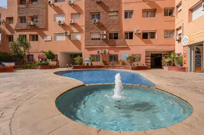 a fountain in a courtyard in front of a building at Luxury 2BR Apt in Gueliz, Pools, Parking,Elevator in Marrakech