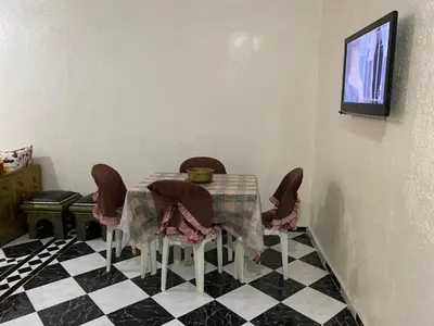 a dining room with a table and chairs on a checkered floor at Garden View Comfort Apartment in Marrakech
