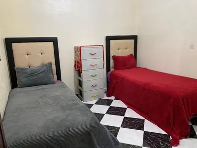 a bedroom with two beds and a checkerboard floor at Garden View Comfort Apartment in Marrakech