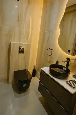 a bathroom with a black sink and a toilet at Appartement Confort & Sérénité Mabroka Marrakech in Marrakech