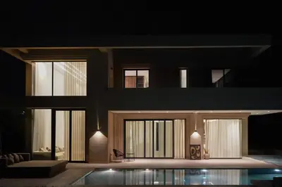 a house with a swimming pool at night at Villa NAHA in Marrakech