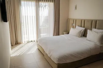 a bedroom with a large bed and a large window at Villa NAHA in Marrakech