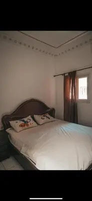 a bedroom with a bed with white sheets and a window at chambres Marrakech in Marrakech