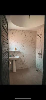 a bathroom with a sink and a marble wall at chambres Marrakech in Marrakech