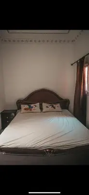 a bed with a wooden headboard in a bedroom at chambres Marrakech in Marrakech