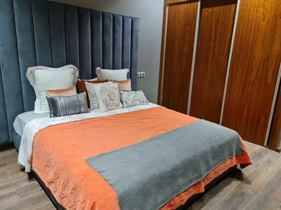 a bedroom with a large bed with an orange blanket at Villa Starlight in Marrakech