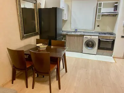 a kitchen with a dining room table and a washing machine at studio design prestigia jad in Marrakech