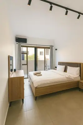 a bedroom with a large bed and a large window at Cozy Appartement avec jacuzzi chauffant in Marrakech