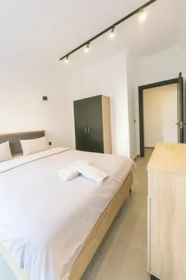a bedroom with a large bed with white sheets at Cozy Appartement avec jacuzzi chauffant in Marrakech