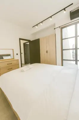 a large white bed in a room with a window at Cozy Appartement avec jacuzzi chauffant in Marrakech