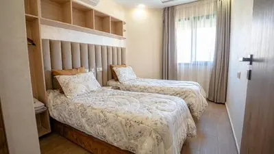 a hotel room with two beds and a window at Bel appart vue piscine dans résidence sécurisée in Marrakech