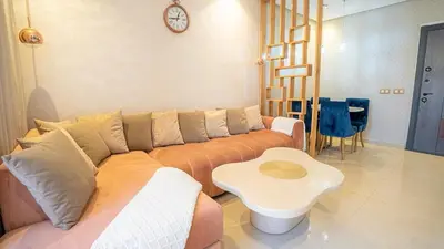 a living room with a couch and a table at Bel appart vue piscine dans résidence sécurisée in Marrakech