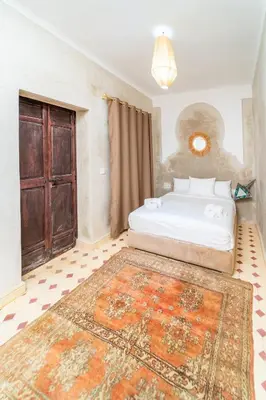 a bedroom with a bed and a large rug at Riad Lalla Fatima Marrakech in Marrakech