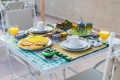 a breakfast table with breakfast foods and orange juice at Riad Lalla Fatima Marrakech in Marrakech