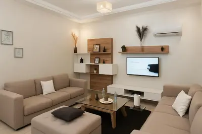 a living room with a couch and a tv at Superbe Duplex moderne à Izdihar in Marrakech