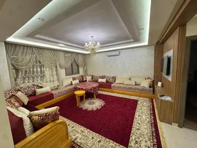 a living room with couches and a chandelier at حدائق حي شريفية بوعكاز مراكش in Marrakech
