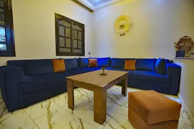 a blue couch in a living room with a table at la villa cozy in Marrakech