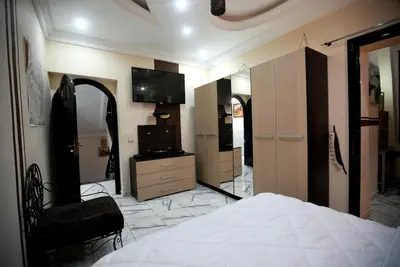 a bedroom with a bed and a tv and a mirror at la villa cozy in Marrakech