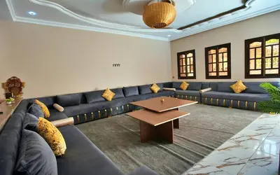 a living room with a blue couch and a table at la villa cozy in Marrakech
