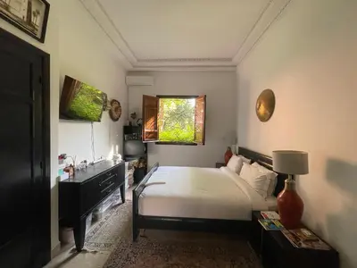 a bedroom with a bed and a sink and a window at Riad Wael in Marrakech