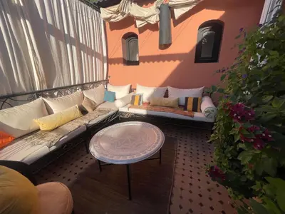 a balcony with a couch and a table at Riad Wael in Marrakech