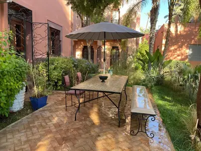 a patio with a table and an umbrella at Riad Wael in Marrakech