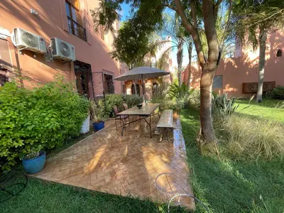 a patio with a table and an umbrella next to a building at Riad Wael in Marrakech