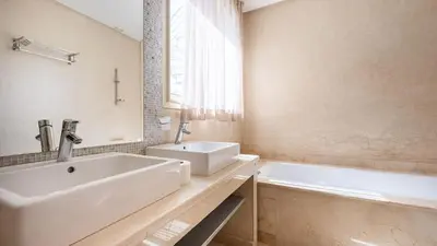 a white bathroom with a sink and a tub at Villa de luxe in Marrakech