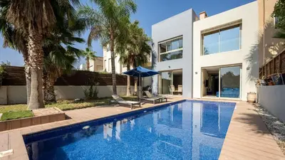a swimming pool in front of a house at Villa de luxe in Marrakech