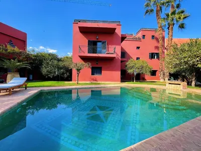 a house with a swimming pool in front of a building at Maison Yves st Laurent - Piscine in Marrakech