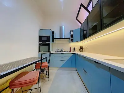 a kitchen with blue cabinets and orange chairs in it at Maison Yves st Laurent - Piscine in Marrakech