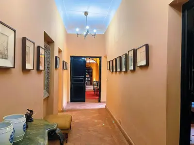 a hallway with a blue ceiling with pictures on the walls at Maison Yves st Laurent - Piscine in Marrakech