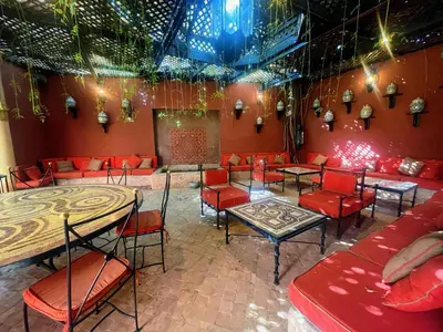 a restaurant with red chairs and tables in a room at Maison Yves st Laurent - Piscine in Marrakech