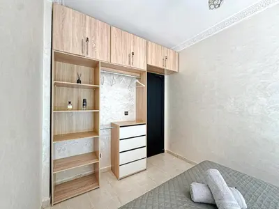 a bedroom with wooden cabinets and a bed in a room at Elegance and comfort in Marrakech Top Location in Marrakech