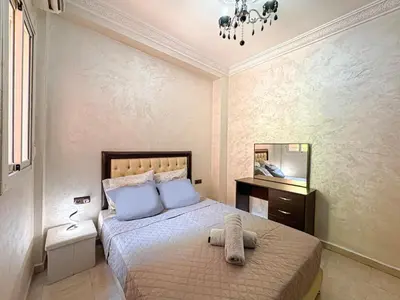 a bedroom with a bed with blue pillows and a mirror at Elegance and comfort in Marrakech Top Location in Marrakech