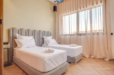 a bedroom with two beds and a large window at Villa joud in Marrakech