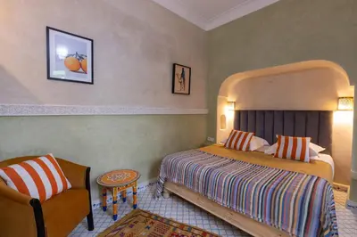 a hotel room with a bed and a chair at Palais el Abbassia in Marrakech