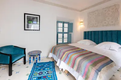 a bedroom with a large bed and a chair at Palais el Abbassia in Marrakech