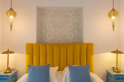 a bedroom with a bed with a yellow headboard at Palais el Abbassia in Marrakech
