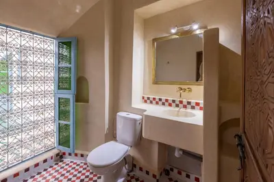 a bathroom with a toilet and a sink and a window at Palais el Abbassia in Marrakech