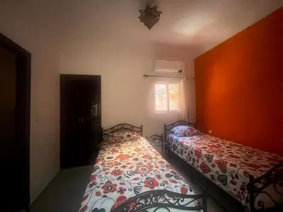 a bedroom with two beds and a window at Riad Nora - Confort, Calme & Sécurité in Marrakech