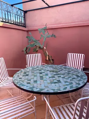 a table with three chairs and a table with a blue and white at Riad Nora - Confort, Calme & Sécurité in Marrakech