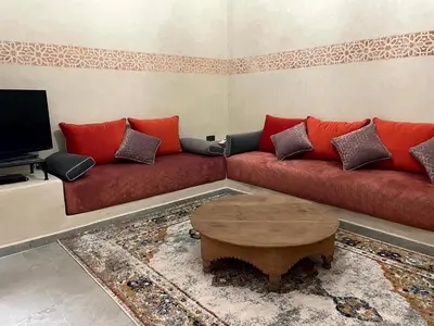 a living room with a red couch and a coffee table at Riad Nora - Confort, Calme & Sécurité in Marrakech