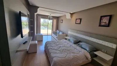 a bedroom with a bed and a television in it at marrakech village in Marrakech