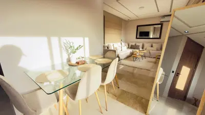 a dining room and living room with a glass table and chairs at Calm Cozy Blue Loft Modern Stay in Marrakech