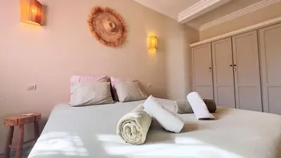 a bedroom with a bed with white sheets and pillows at Villa Bella Marrakech avec piscine sans vis-à-vis 9 min du centre in Marrakech